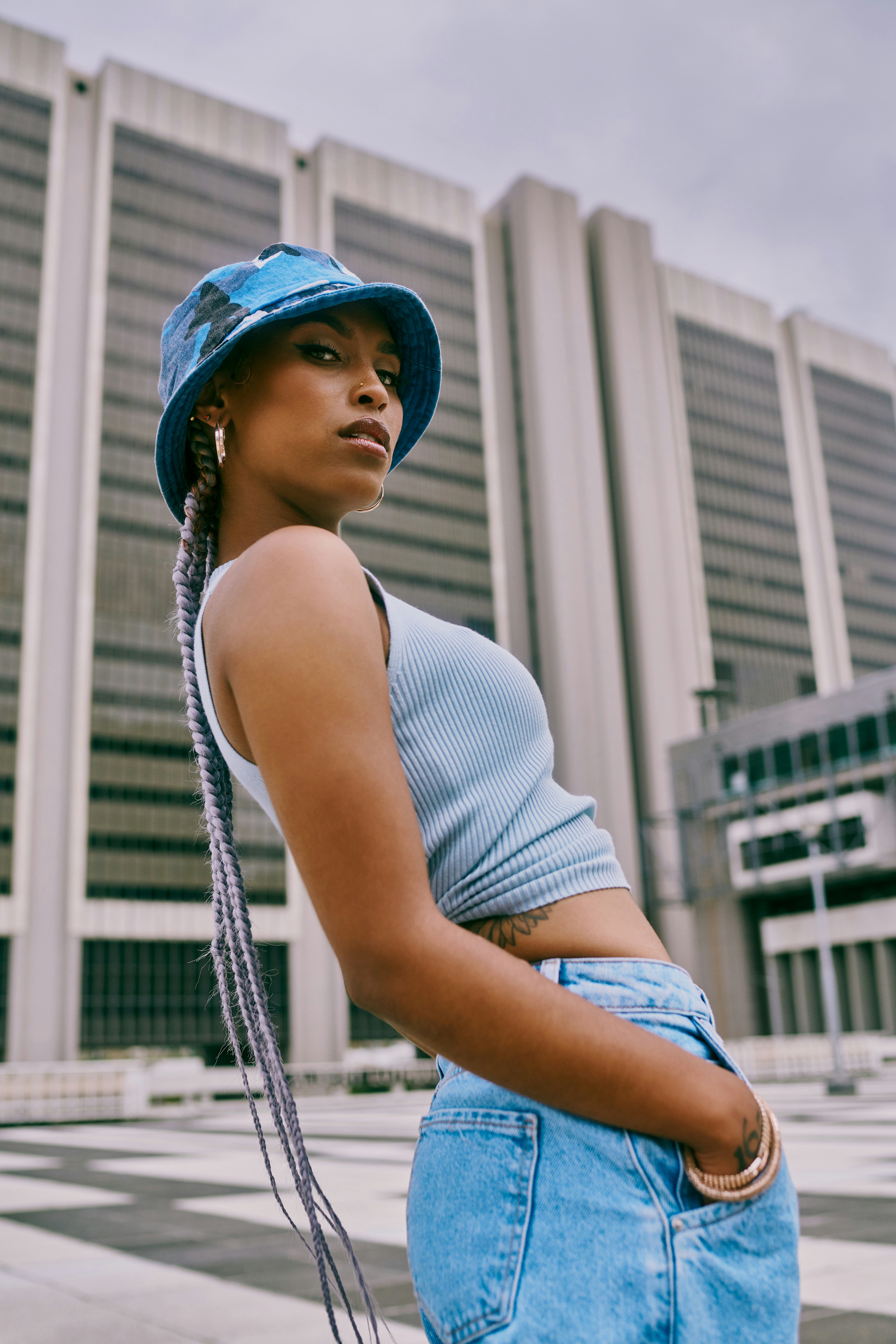 Young woman wearing bucket hat leans back as she thinks about the new moon in cancer on June 28, 202...