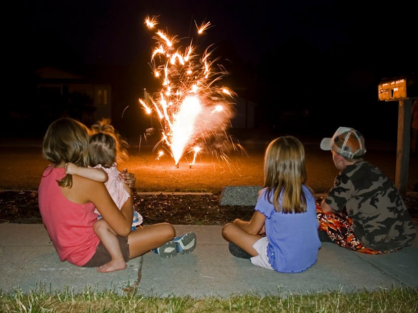 A family watching fireworks at home from a safe distance, after ensuring you can light fireworks in ...