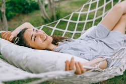 a woman lies on the hammock in the garden. The june 2022 new moon will affect these zodiac signs the...