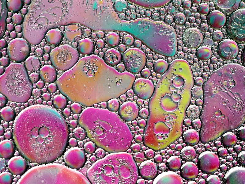 Macrophotography of oil on water, creating an abstract bubble and crater pattern