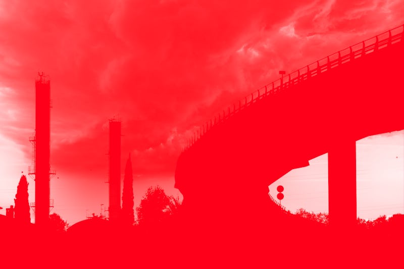 Elevated bridge in an industrial area with chemical factory chimneys