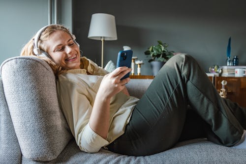 A woman looks at her phone, trying to figure out how to delete Hinge. You can delete it or pause or ...