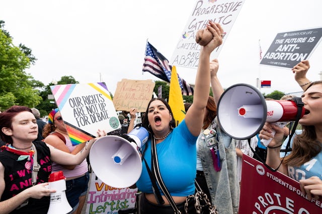 Pro-choice and pro-life activists protest outside of the U.S. Supreme Court as they wait for the cou...