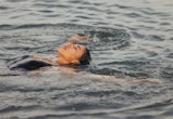 A woman swims backstroke at a lake. Here's how the june 2022 new moon will affect each zodiac sign; ...