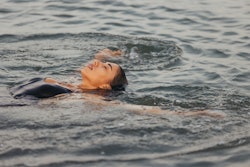 A woman swims backstroke at a lake. Here's how the june 2022 new moon will affect each zodiac sign; ...