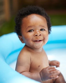 a baby boy in an inflatable pool, which should be kept clean to keep kids safe