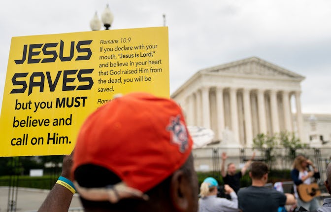 A person holds a Jesus Saves sign outside the US Supreme Court in Washington, DC, on June 27, 2022. ...