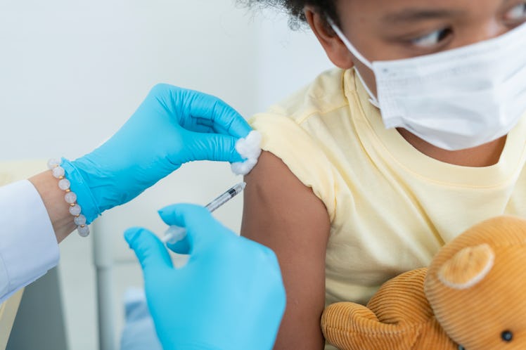 Close up of a doctor giving a child under 5 the COVID vaccine.
