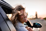 Young woman enjoying road trip while leaning on a car window. Here's your guide to air signs. Air si...