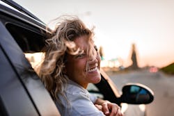 Young woman enjoying road trip while leaning on a car window. Here's your guide to air signs. Air si...