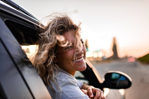 Young woman enjoying road trip while leaning on a car window. Here’s your guide to air signs. Air si…