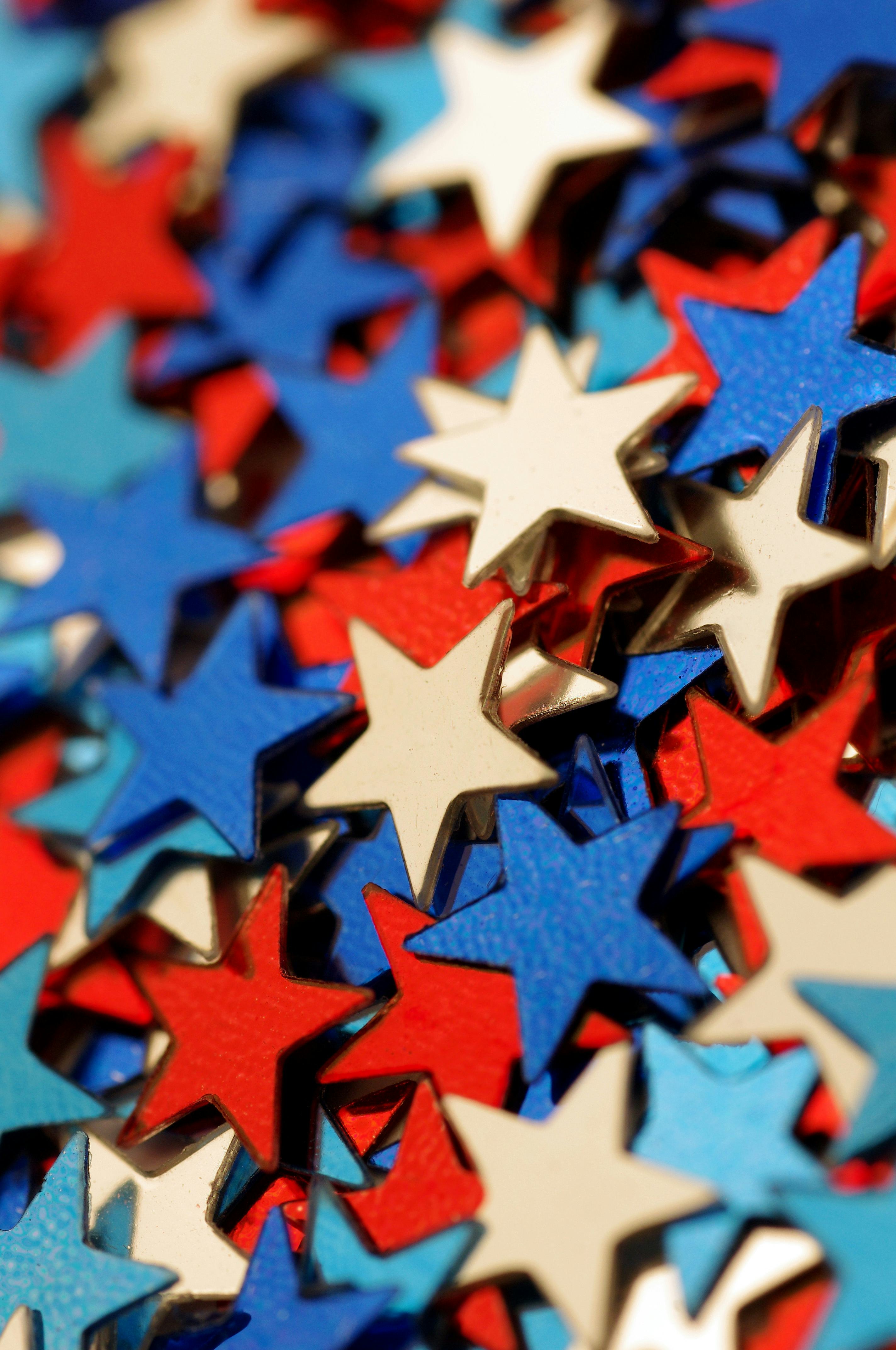 Macro shot of red, white, and blue star-shaped glitter/confetti.