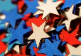 Macro shot of red, white, and blue star-shaped glitter/confetti.