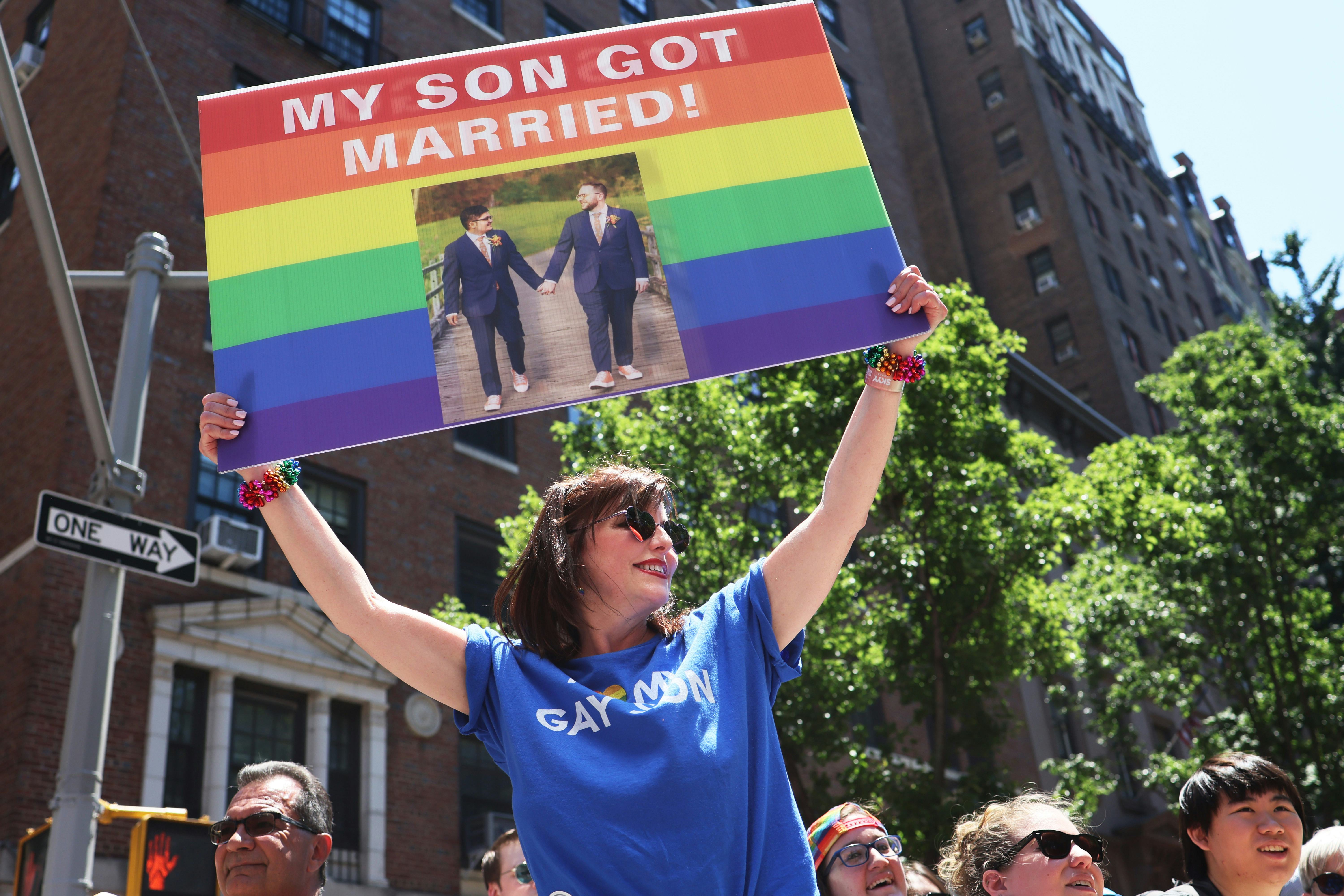 NEW YORK, NEW YORK - JUNE 26: Angela Ghiozzi holds up a sign as she watches the New York City Pride ...
