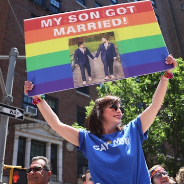 NEW YORK, NEW YORK - JUNE 26: Angela Ghiozzi holds up a sign as she watches the New York City Pride ...