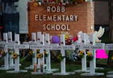  White crosses marking the deaths are pictured in front of Robb Elementary School in Uvalde, Texas e...