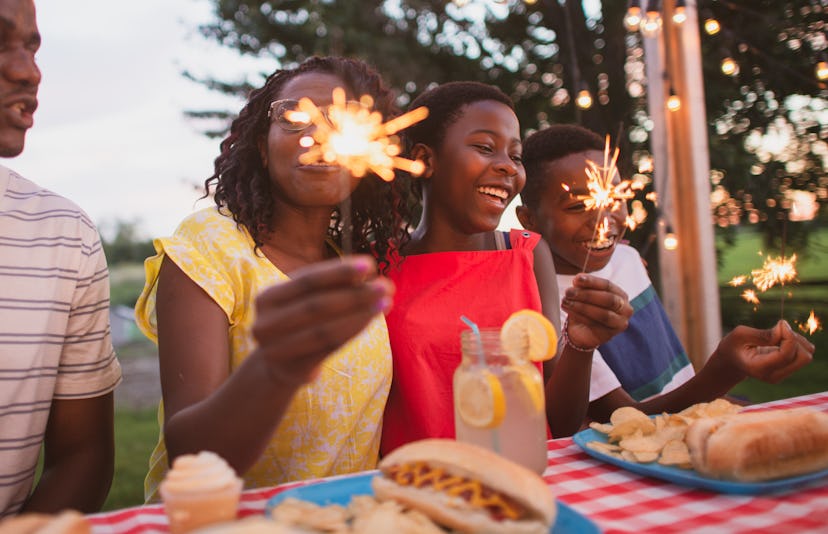 A family sitting at a table playing with sparklers, can you light fireworks in a public place