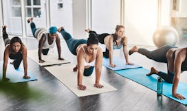 Full length shot of a group of pregnant women doing pilates together in studio in an article about i...