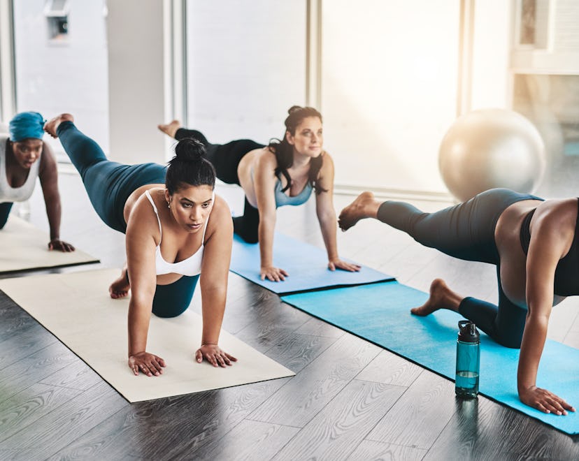Full length shot of a group of pregnant women doing pilates together in studio in an article about i...