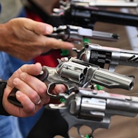 Attendees hold Ruger revolver pistols during the National Rifle Association (NRA) Annual Meeting at ...