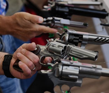 Attendees hold Ruger revolver pistols during the National Rifle Association (NRA) Annual Meeting at ...