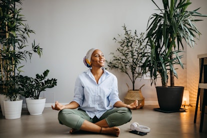 Woman is sitting on the floor doing yoga, relaxing