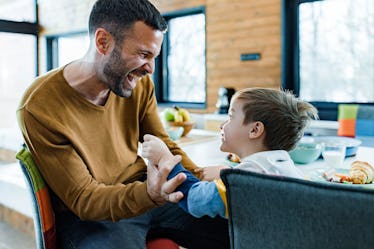 Cheerful father and his small boy having fun at home.