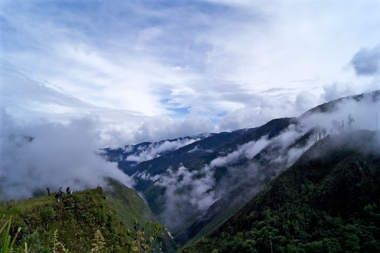 Mugi Valley, Occidental Papua, Indonesia - May 2014: trekking guide and porter on top of Mugi Valley...
