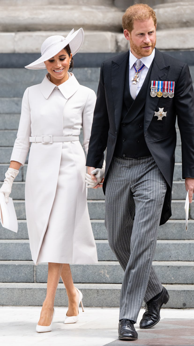 Meghan Markle, Duchess of Sussex and Prince Harry, Duke of Sussex hold hands at the platinum jubilee...