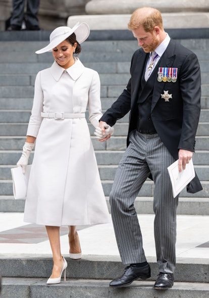 meghan markle wearing a white dior coat dress, wide-brim hat, and matching pumps with prince harry a...