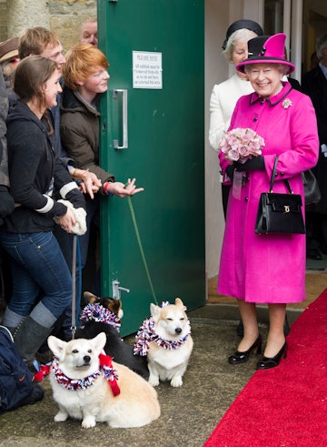 Britain's Queen Elizabeth II (R) meets members of the public with two corgi dogs during a visit at S...