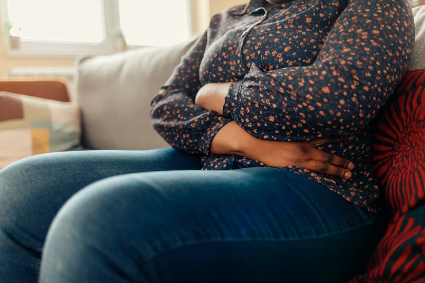 A woman sitting bloated which can be a sign of sugar intolerance