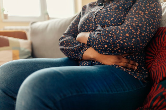 A woman sitting bloated which can be a sign of sugar intolerance