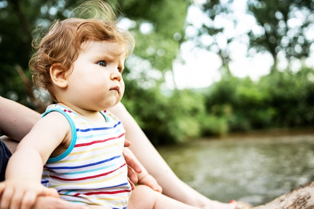 Baby girl with a U name on a picnic outdoors looking skeptical in an article round up of baby girl n...