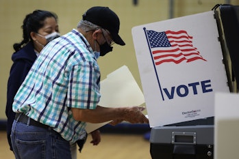 ALEXANDRIA, VIRGINIA - JUNE 21: A man casts his ballot at a polling station at Rose Hill Elementary ...