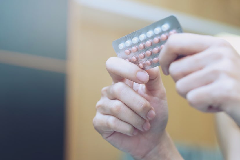 Woman hands opening a birth control pills package