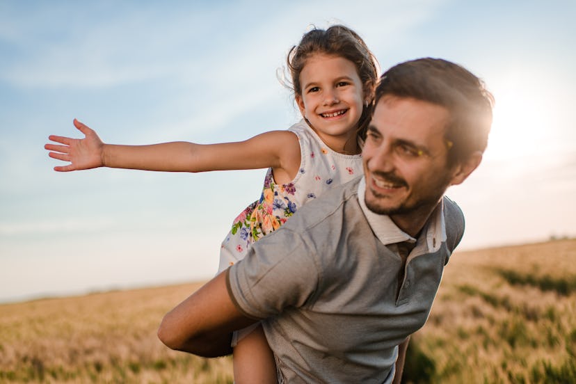 Girl and father in a field laughing at in a field at father's day riddles 