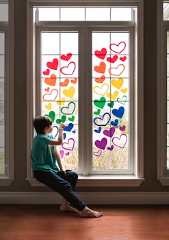 adding heart window decals in a rainbow of colors is a cute Pride craft idea you can do with kids
