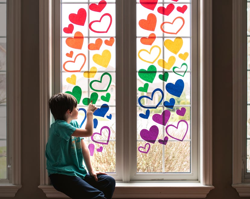 adding heart window decals in a rainbow of colors is a cute Pride craft idea you can do with kids