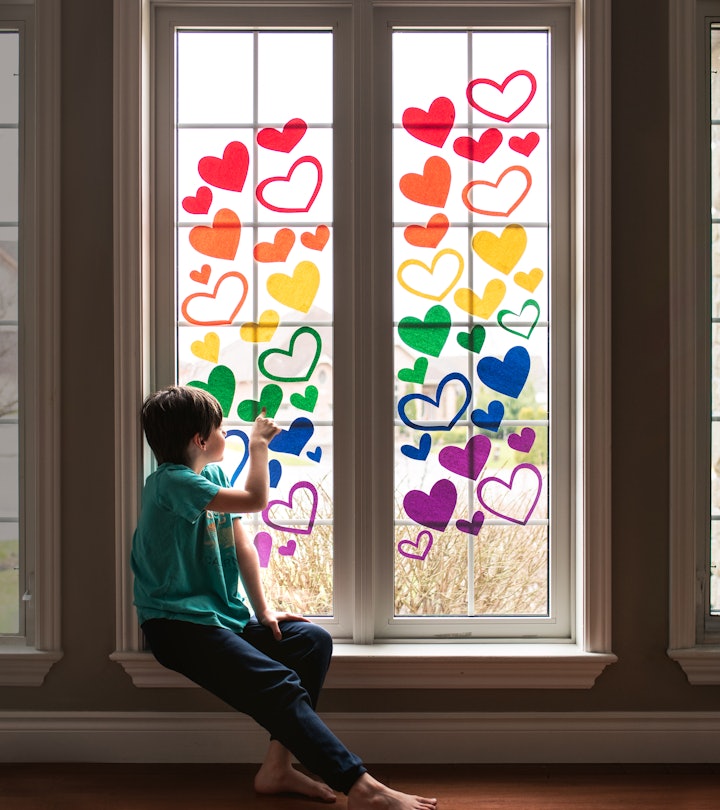 adding heart window decals in a rainbow of colors is a cute Pride craft idea you can do with kids