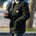 PARIS, FRANCE - NOVEMBER 18: A passerby wears a khaki hoodie sweater, a khaki with white sheep inter...