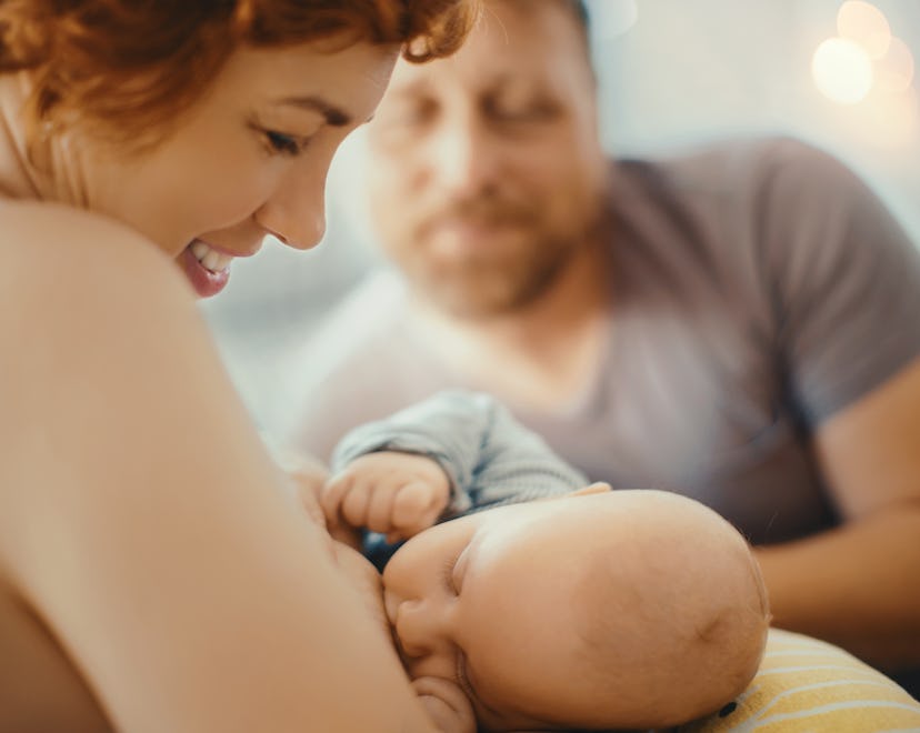 woman breastfeeding with partner in background, how can dads help with breastfeeding