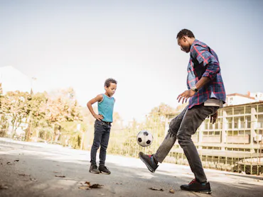 Father and son playing soccer