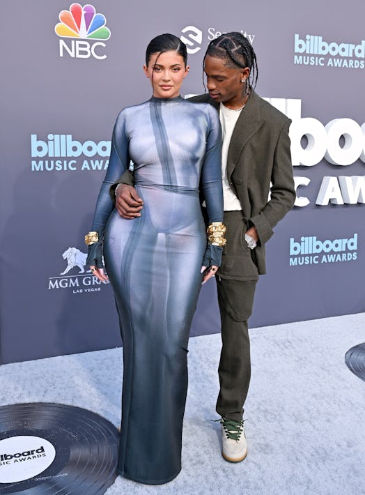 Kylie Jenner wearing a blue Balmain 'naked' dress with Travis Scott at the 2022 Billboard Music Awar...