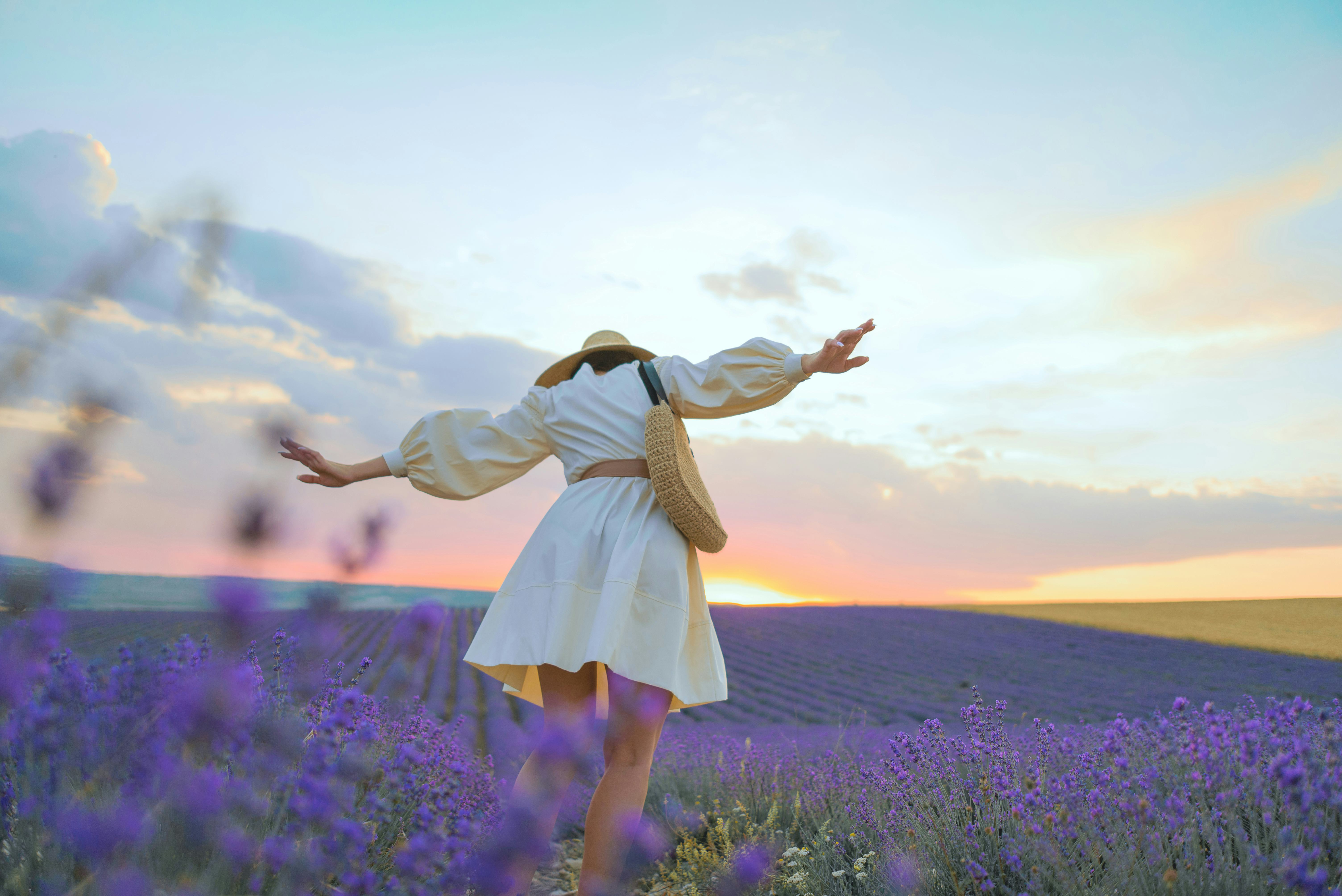 A young woman in a straw hat, an ivory dress and an eco-style handbag in lavender fields. Your do's ...