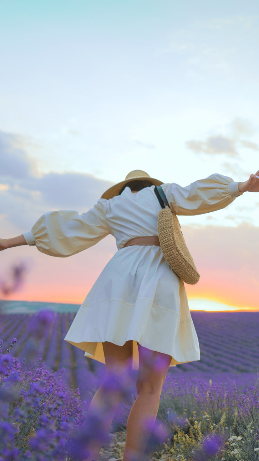 A young woman in a straw hat, an ivory dress and an eco-style handbag in lavender fields. Your do's ...