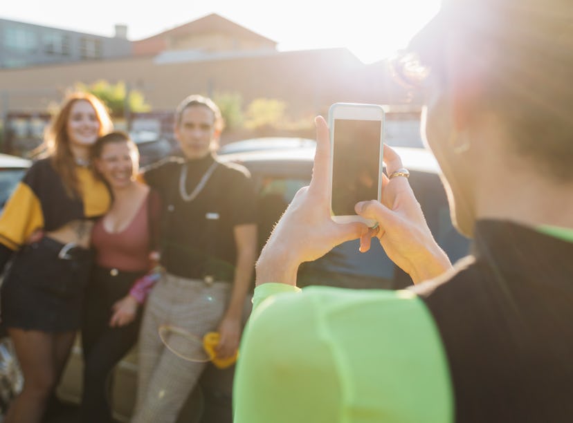 A friend takes a picture of their friends using posing tips for how to pose for pictures.