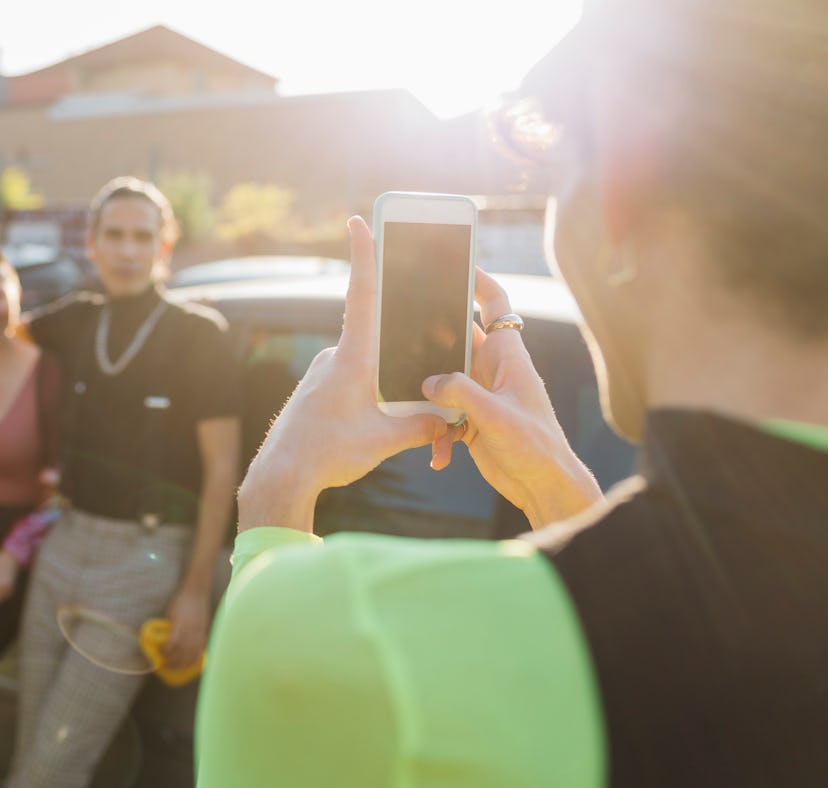 A friend takes a picture of their friends using posing tips for how to pose for pictures.