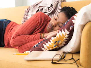 A woman sleeping on the couch may need home products that'll help you fall asleep faster or improve ...