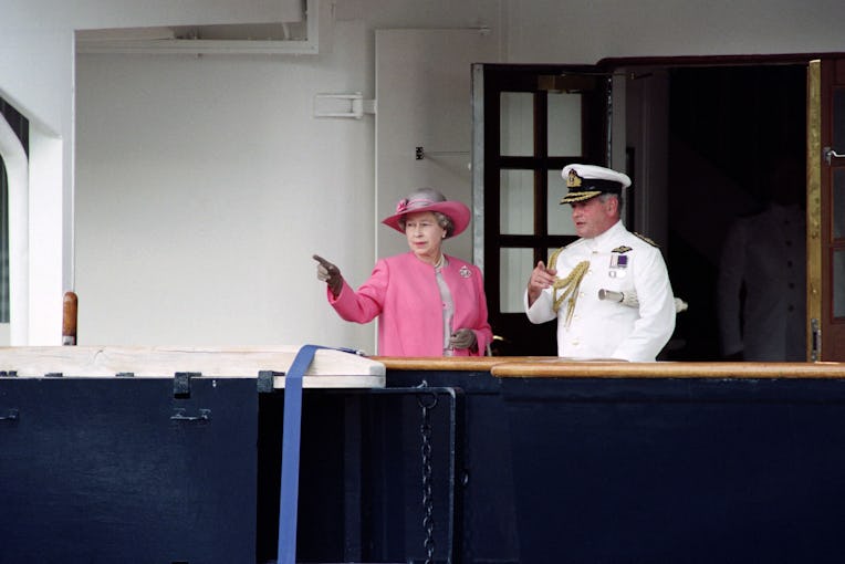 Queen Elizabeth II converses with the captain of the royal yacht "Britannia" in Bordeaux on June 11,...